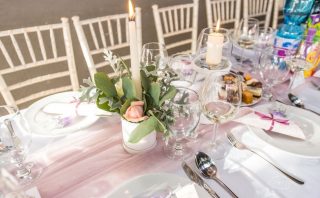 Beautifully arranged dining table for an elegant occasion with floral centerpiece and candles.