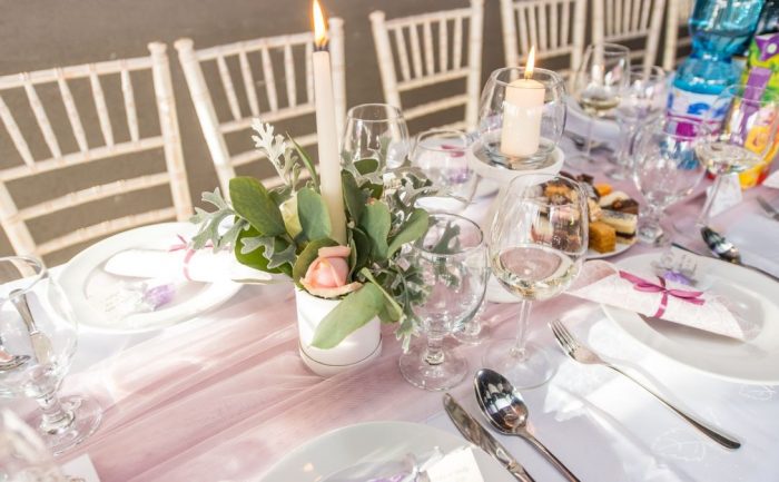 Beautifully arranged dining table for an elegant occasion with floral centerpiece and candles.